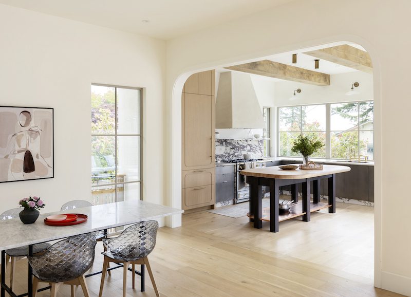 a vast arched entrance framing a unique custom french farmhouse inspired kitchen that is modest in size