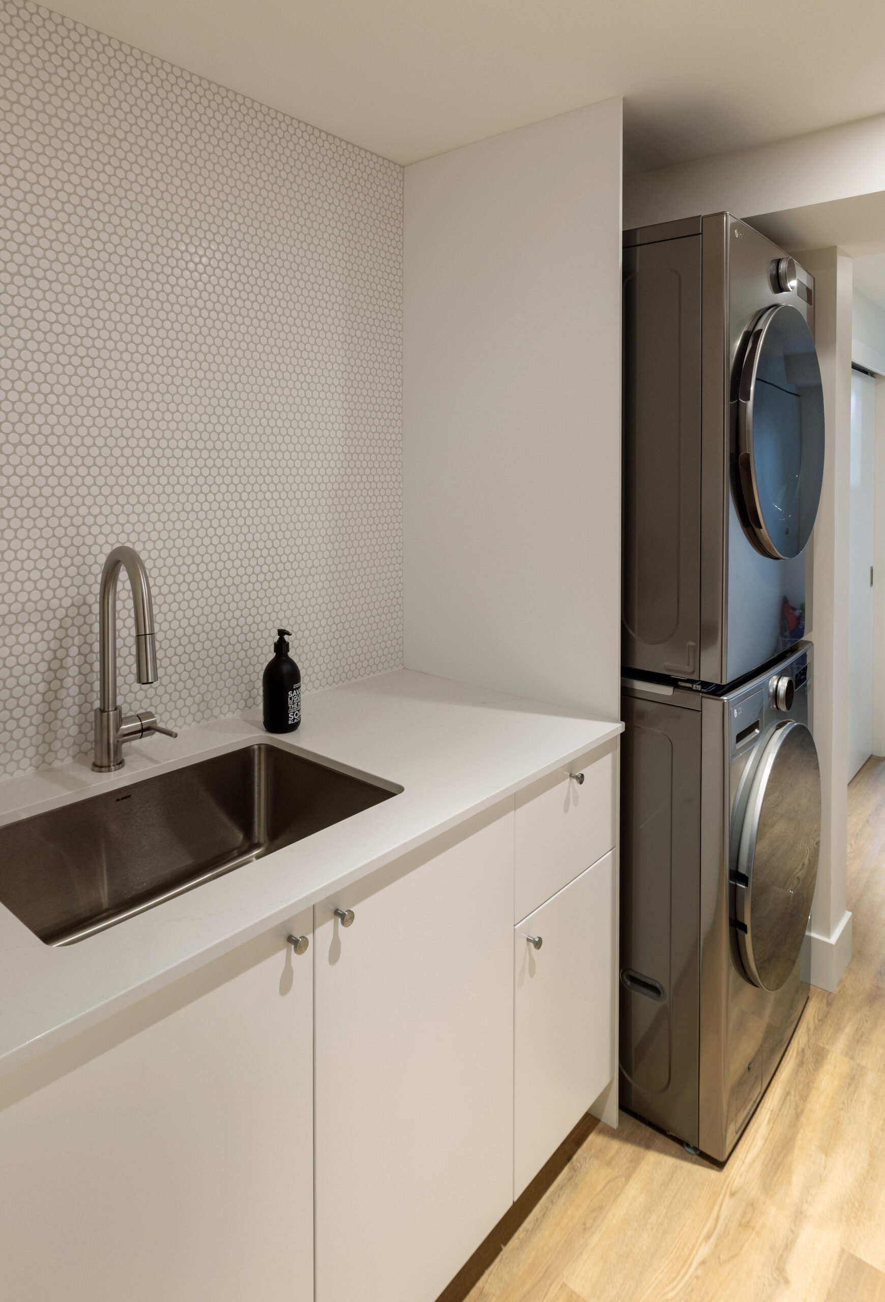 Laundry room with sink, storage, and folding counter custom home features at Brightwater custom home by Hasler Homes
