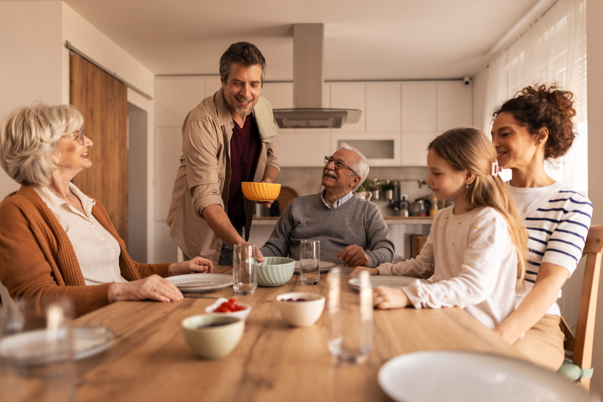 Intergenerational family having lunch and discussing building a multi-generational home in North Vancouver