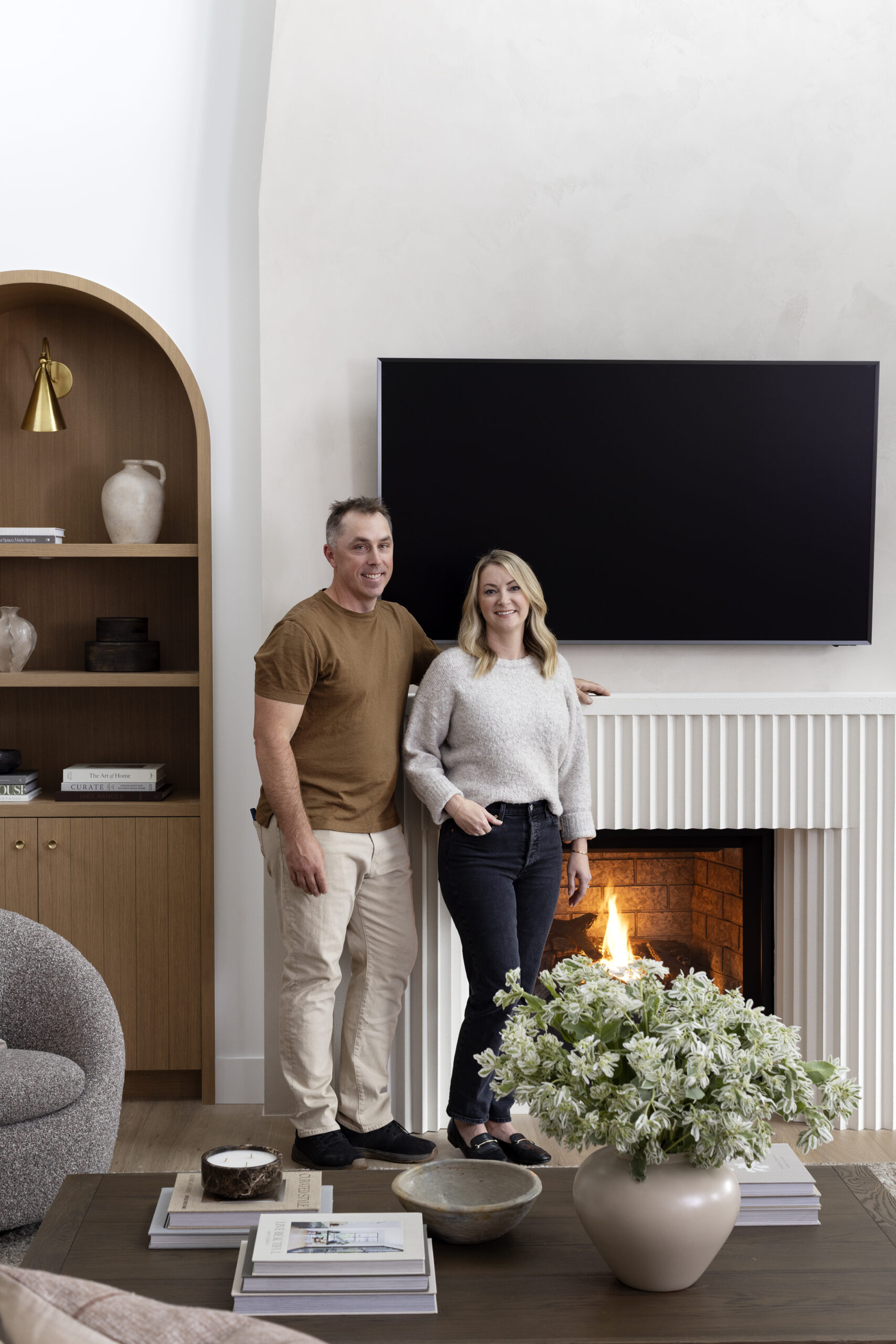 Natalie and Greg Hasler in front of the fireplace at Haven (Net Zero Lifestyle)