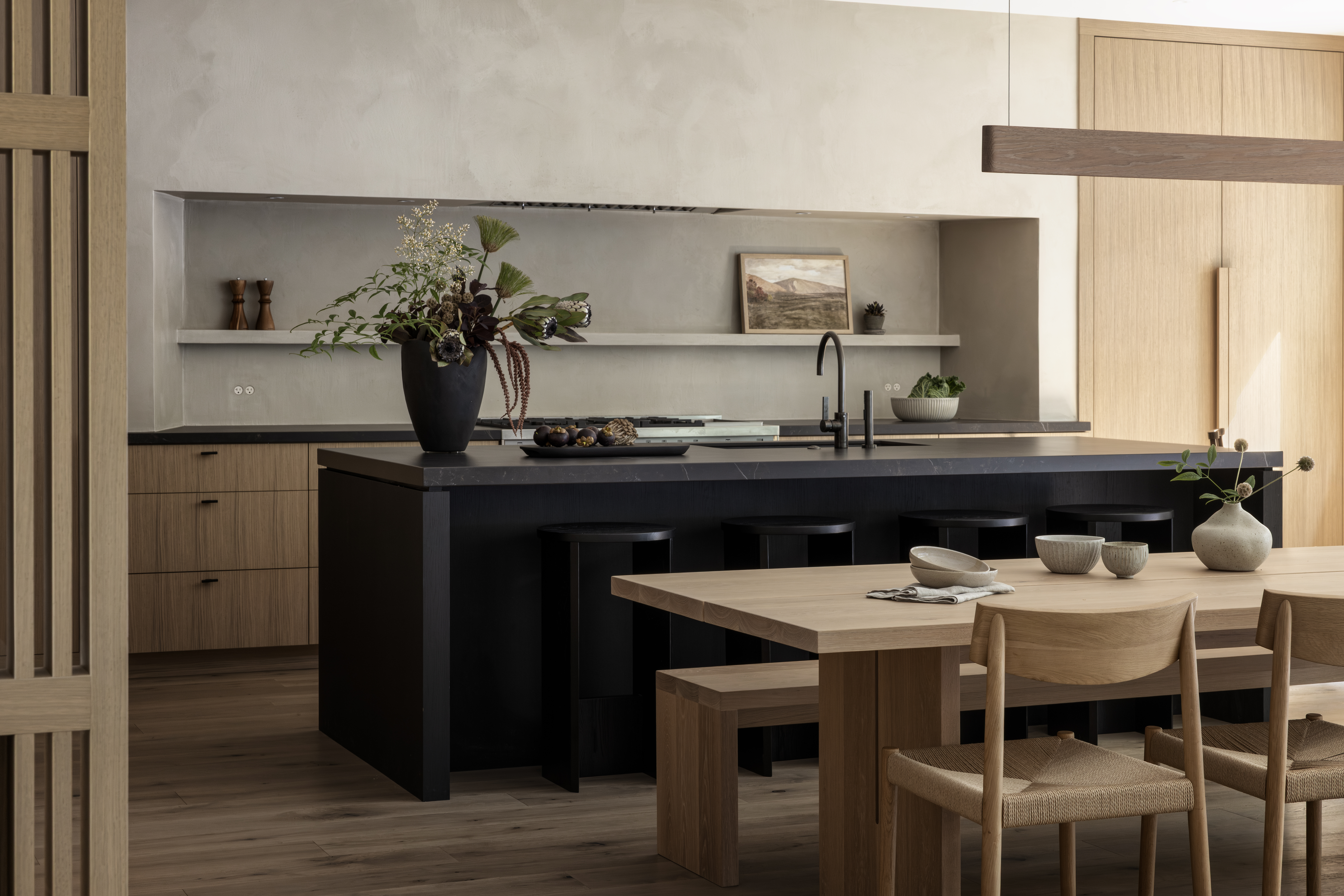 Japandi kitchen with rift-cut oak cabinets, oversized island, and large dining table