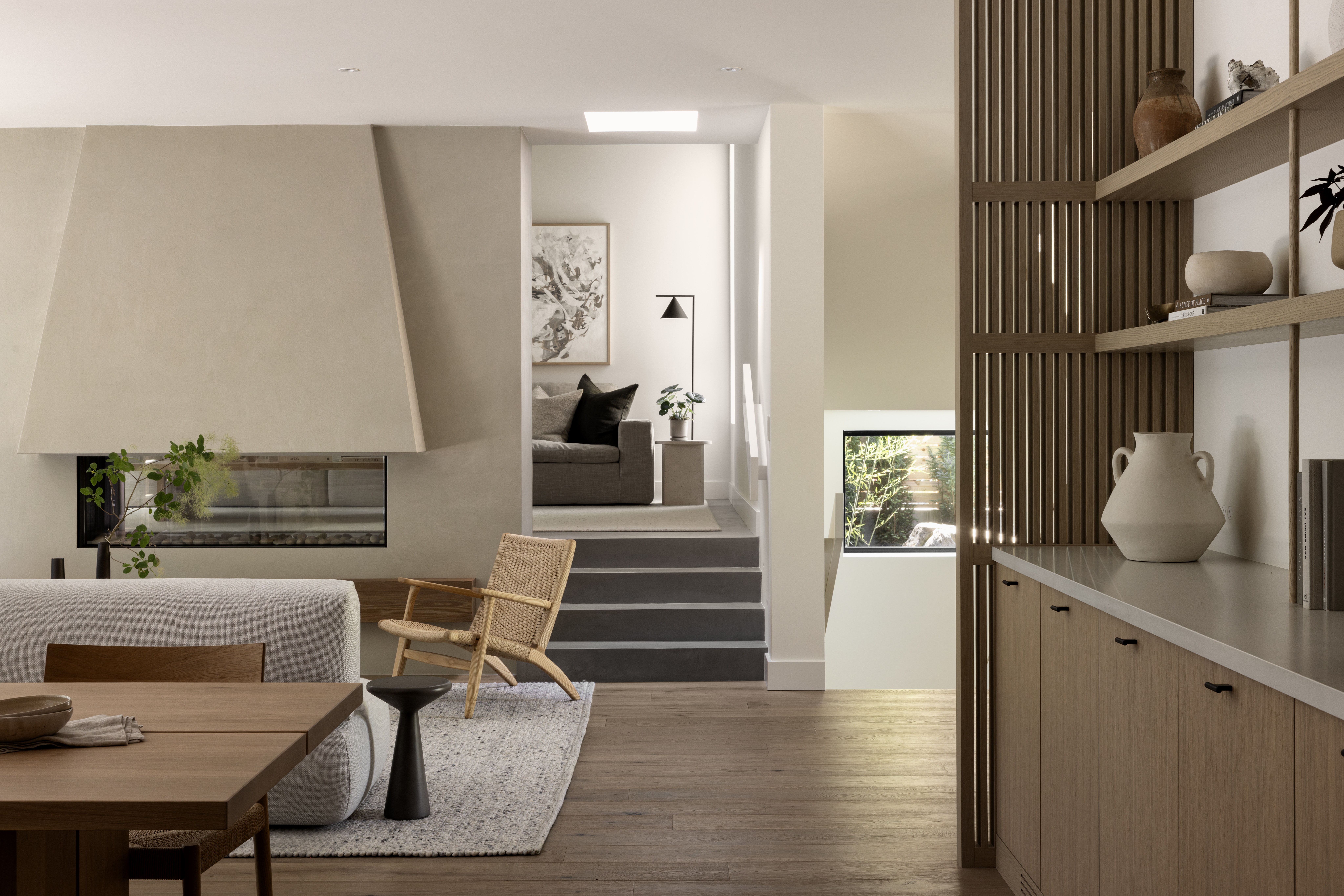 Open-plan living room and custom fireplace finished in microtopping at Japandia