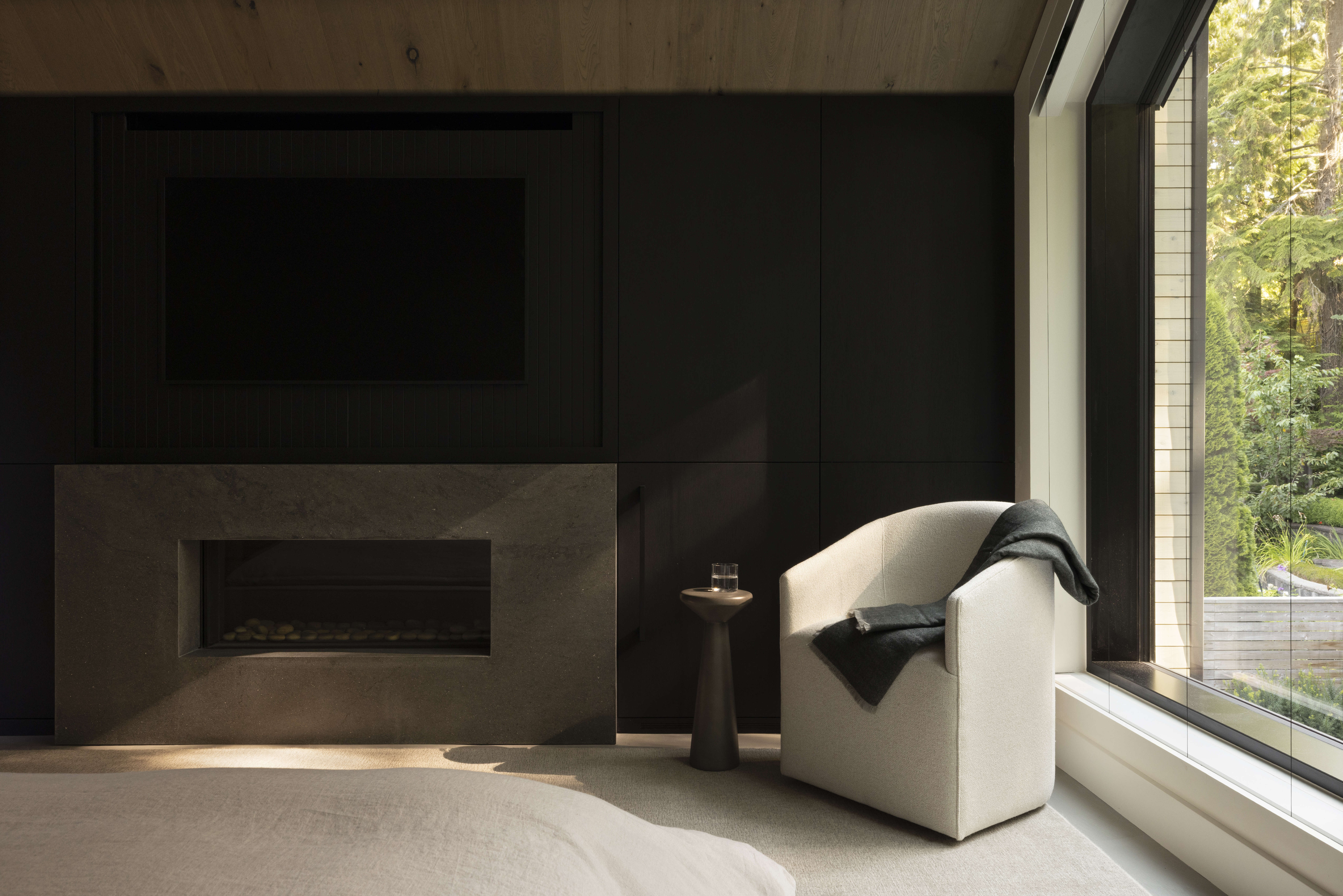 Primary bedroom sitting area with custom fireplace at Japandi home in North Vancouver