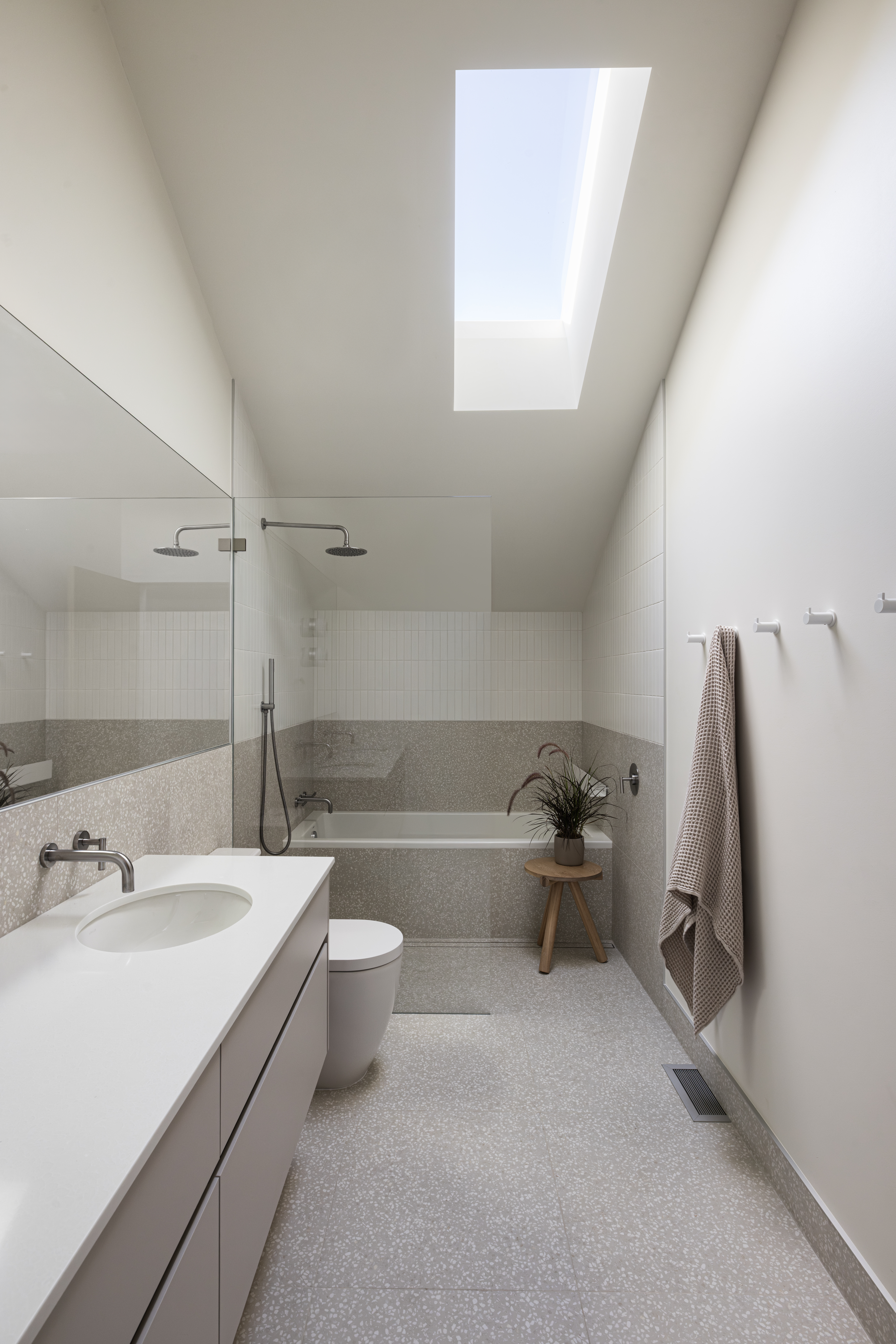 Upstairs bathroom with skylight and large vanity at Japandia residence in North Vancouver